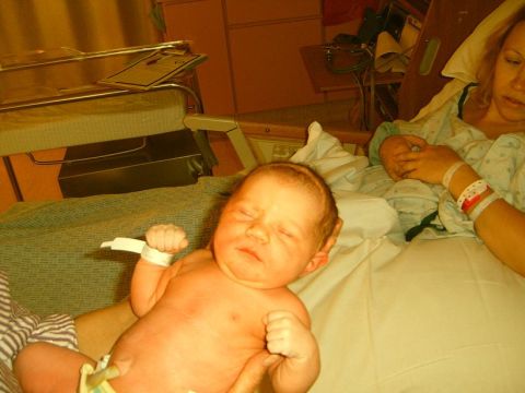 2001 Pontiac Trans Am - A newborn baby rests in a hospital bed, with a woman in the background.