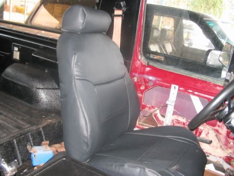 1991 Ford Bronco - Interior view of a vehicle showing a black seat and the door's internal components.