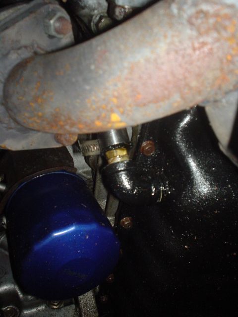 1995 Ford Probe - Close-up view of an engine oil filter and exhaust manifold components.