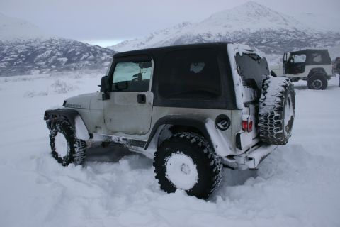 2003 Jeep TJ - Two Jeeps navigating deep snowdrifts in a mountainous, winter landscape.