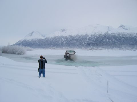 2003 Jeep TJ - A 2003 Jeep TJ navigates through icy water in a snowy landscape.