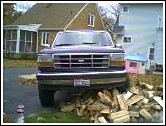 1993 Ford Bronco - A Ford Bronco is parked in front of a house, with firewood stacked in front of it.