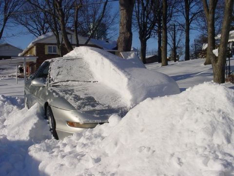 1994 Ford Probe - A silver 1994 Ford Probe is almost completely covered by a large snowdrift after a winter storm.