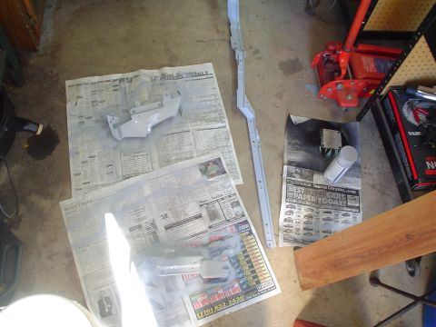 1984 Ford Bronco - Car parts are laid out on newspapers and being spray-painted in a garage setting.