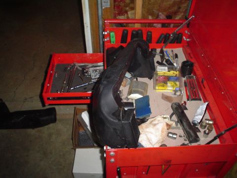 1984 Ford Bronco - A red toolbox is open, revealing tools and a black automotive part, suggesting a repair or rebuild project.