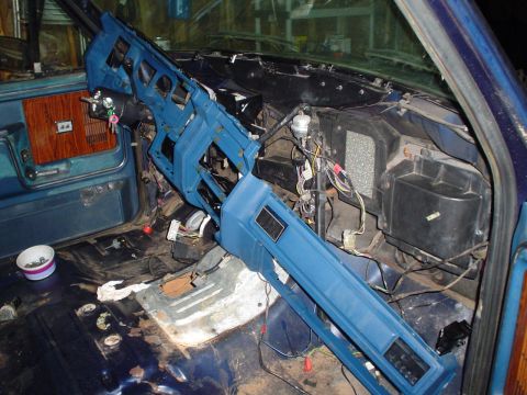1984 Ford Bronco - The interior of a vehicle is shown with the dashboard removed, revealing wiring and components during a rebuild.