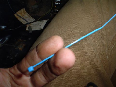 1984 Ford Bronco - Close-up of interior wiring and a blue zip tie being held by fingers.
