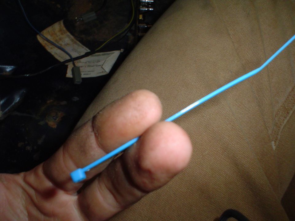 Interior wiring and blue zip tie held by fingers