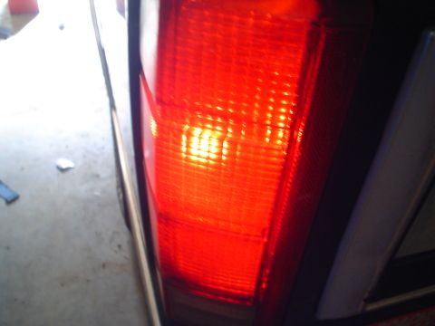 1984 Ford Bronco - Close-up of a red vehicle taillight with the bulb illuminated.