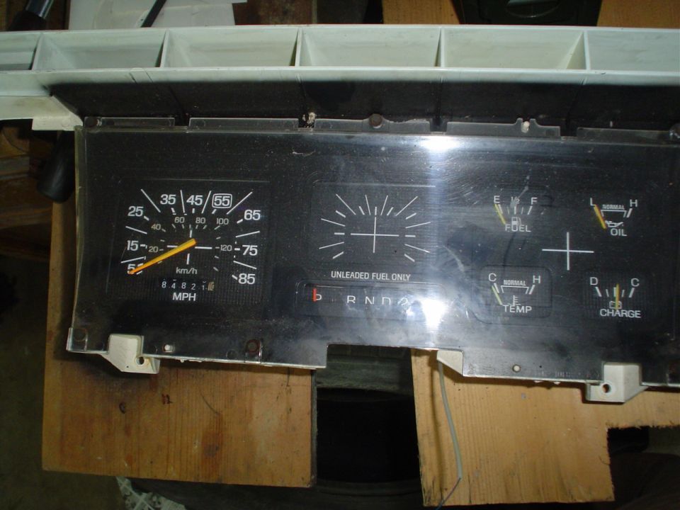Dashboard gauges with speedometer, fuel, oil, temp, and charge indicators. Shows 'R N D A' gear selector