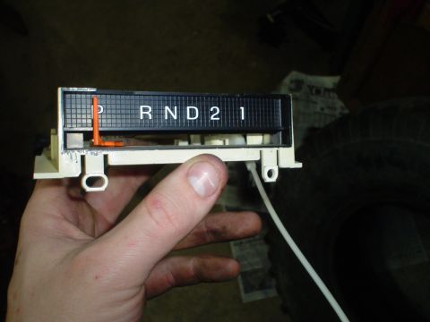 1984 Ford Bronco - A hand holds an automatic transmission gear selector indicator panel with visible gear selections.