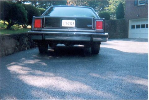 1982 Ford Crown Victoria LTD - This Ford sedan's rear end is visible, parked in a driveway with a garage in the background.