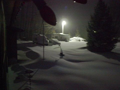 1993 Ford Probe - A winter scene shows a trailer and two vehicles covered in snow under a bright street light.