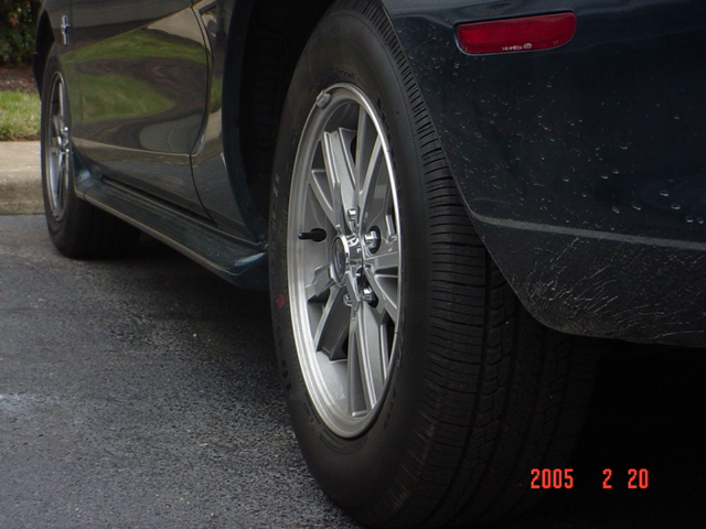 Close-up of a rear alloy wheel and dark quarter panel on a Ford Mustang, dated 2005 2 20