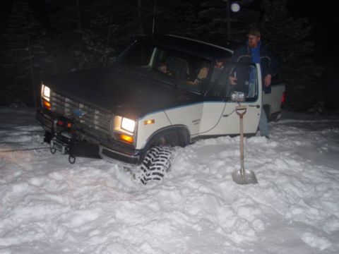 1986 Ford Bronco - This Ford pickup truck is stuck in the snow with a winch attached to the front.
