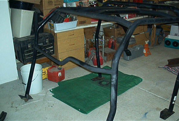 Black roll cage on green tarp in garage