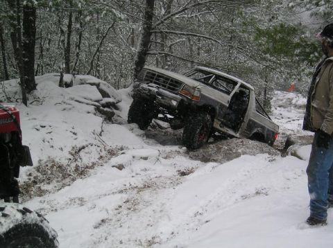 1995 Ford Bronco - A modified truck attempts to climb a rocky, snow-covered trail.