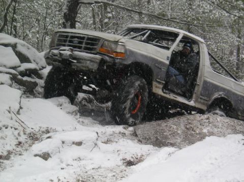 1995 Ford Bronco - Modified 1995 Ford Bronco tackling rough terrain during a snowy day.