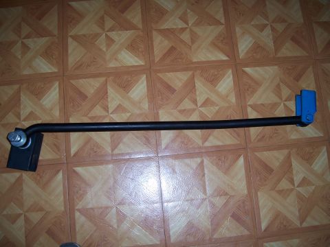 1983 Ford Bronco - A black anti-roll bar with blue and silver hardware is laid out on a tiled floor.
