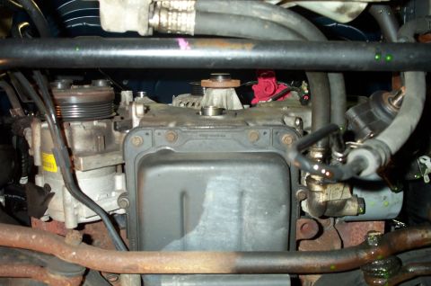 1998 Ford Crown Victoria - Close-up view of an engine compartment, showing the AC compressor and oil pan.