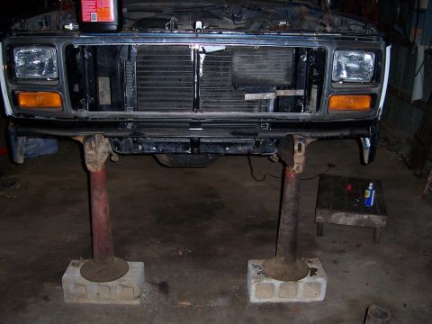 1983 Ford Bronco - Front clip of a Ford truck, likely from the early 1980s, undergoing service with the radiator removed.