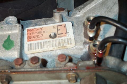 1998 Ford Crown Victoria - Close-up of a vehicle transmission component with a part number label.