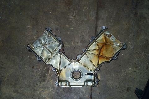 1998 Ford Crown Victoria - A V-shaped engine timing cover with internal bracing and oil residue is shown from a top-down perspective.