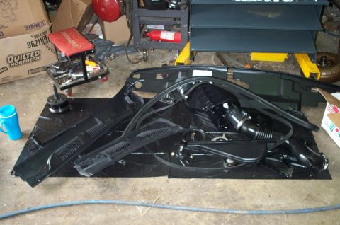 1998 Ford Crown Victoria - Various car components are disassembled and arranged on the floor, possibly for repair or replacement.