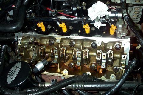 1998 Ford Crown Victoria - Close-up view of a Ford engine, showing yellow fuel injectors and the internal valve train components.