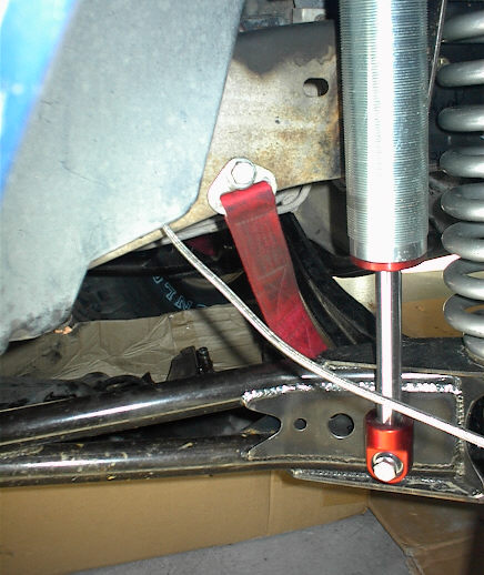 1984 Ford Bronco - Red tow strap and silver shock absorber are visible on the vehicle's frame.