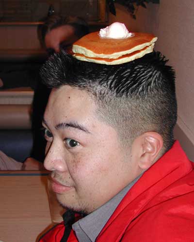1993 Ford Bronco - A person balances a stack of pancakes topped with butter on their head.