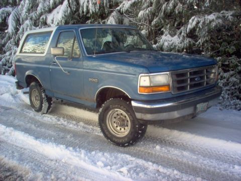 1992 Ford Bronco - Blue 1992 Ford Bronco on a snow-covered road.