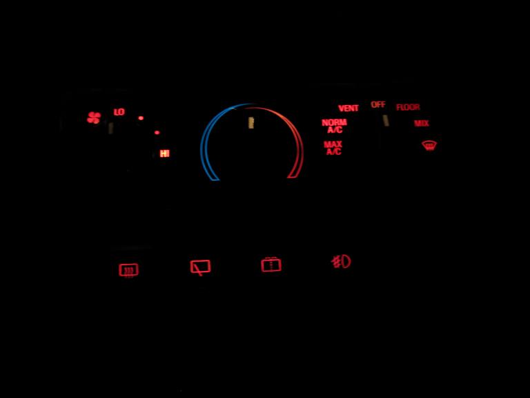 Illuminated car HVAC climate control panel in the dark with red and blue backlighting