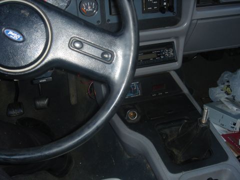 1986 Ford Mustang - Interior view of a car, showing the steering wheel, dashboard gauges, radio, and gear shifter.