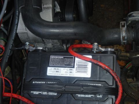 1986 Ford Mustang - Close-up view of a car battery and engine components.
