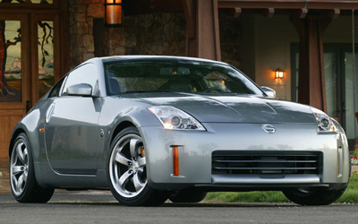 1996 Ford Probe - A silver Nissan 350Z is parked in front of a house with a large porch.