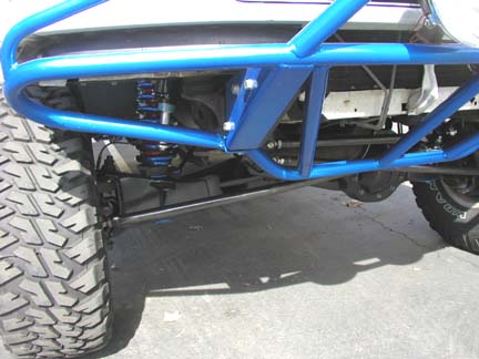 1984 Ford Bronco - The image shows the undercarriage and suspension of a modified off-road vehicle, a blue roll cage.