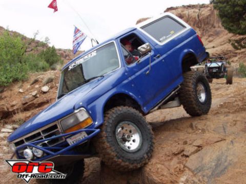 1984 Ford Bronco - This blue 1992 Ford Bronco navigates a challenging off-road trail, with another vehicle following behind.