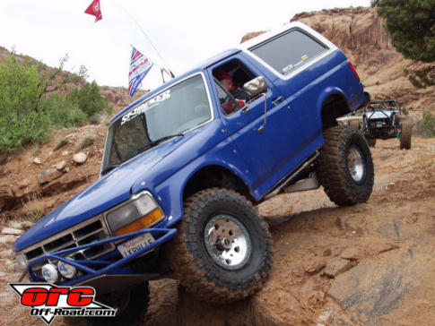 Blue 1992 Ford Bronco off-roading, climbing rocks