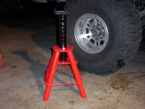 2000 Ford F-450 - A red jack stand is positioned next to a large tire, suggesting vehicle maintenance or repair.