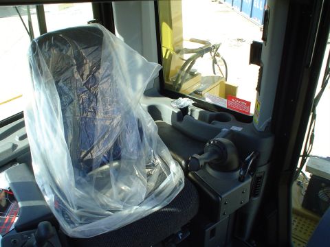 1966 International School Bus - Interior view of a construction vehicle's cabin, showing a seat covered in plastic and various controls.