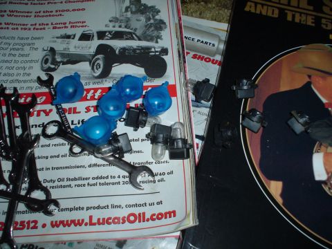 1984 Ford Bronco - Collection of automotive parts and promotional materials, including wrenches and light bulbs.