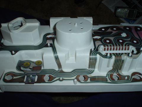 1984 Ford Bronco - The back of a vehicle's instrument cluster shows the intricate wiring harness and circuit board pathways.