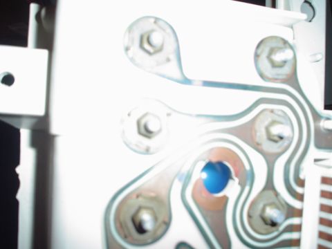 1984 Ford Bronco - Close-up of a white circuit board with metallic connectors and a blue indicator light.