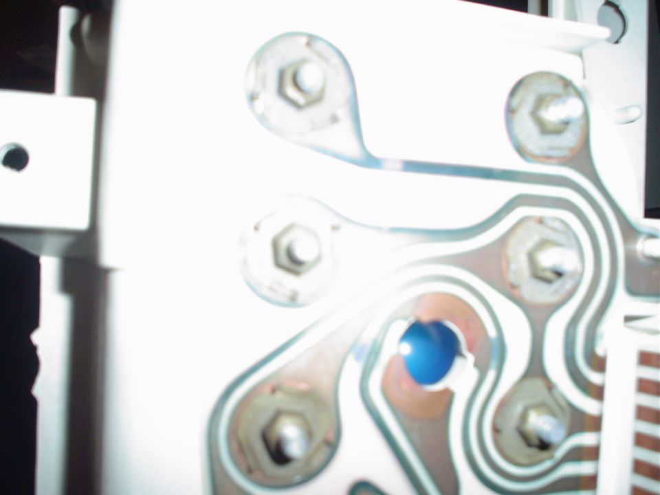 Circuit board with hexagonal bolts and a blue light indicator
