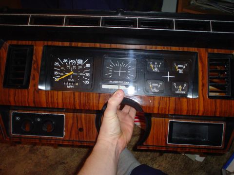 1984 Ford Bronco - Close-up of a vehicle's dashboard gauges, including a speedometer and fuel, oil, temperature, and charge indicators.