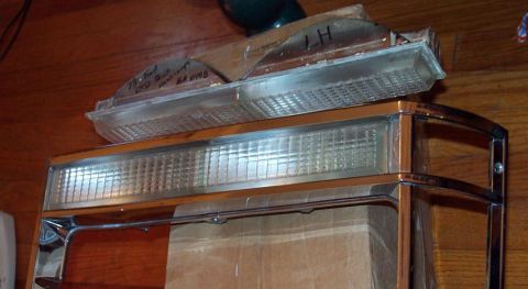 1985 Ford Crown Victoria LTD - A close-up of a 1985 Ford Crown Victoria LTD headlight assembly, showing the chrome trim and a handwritten "LH" label.