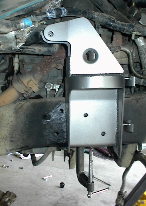 1984 Ford Bronco - Custom bracket installation on a vehicle frame, showing engine and exhaust parts.