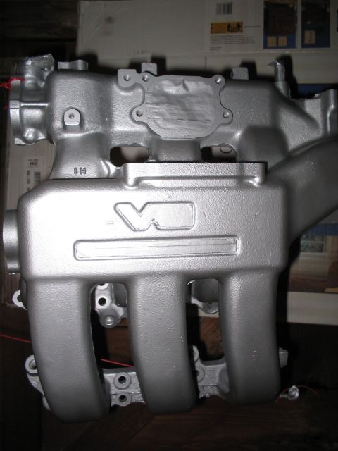 1995 Ford Probe - A silver V6 engine intake manifold is shown, with visible casting marks and part numbers.
