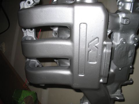 1995 Ford Probe - Close-up of a silver engine intake manifold an embossed 'K' logo and multiple intake runners.